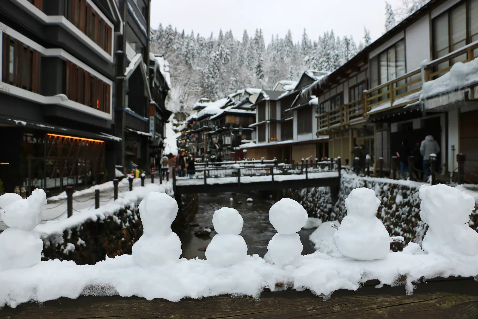 Ginzan Onsen's wooden inns along a snowy river