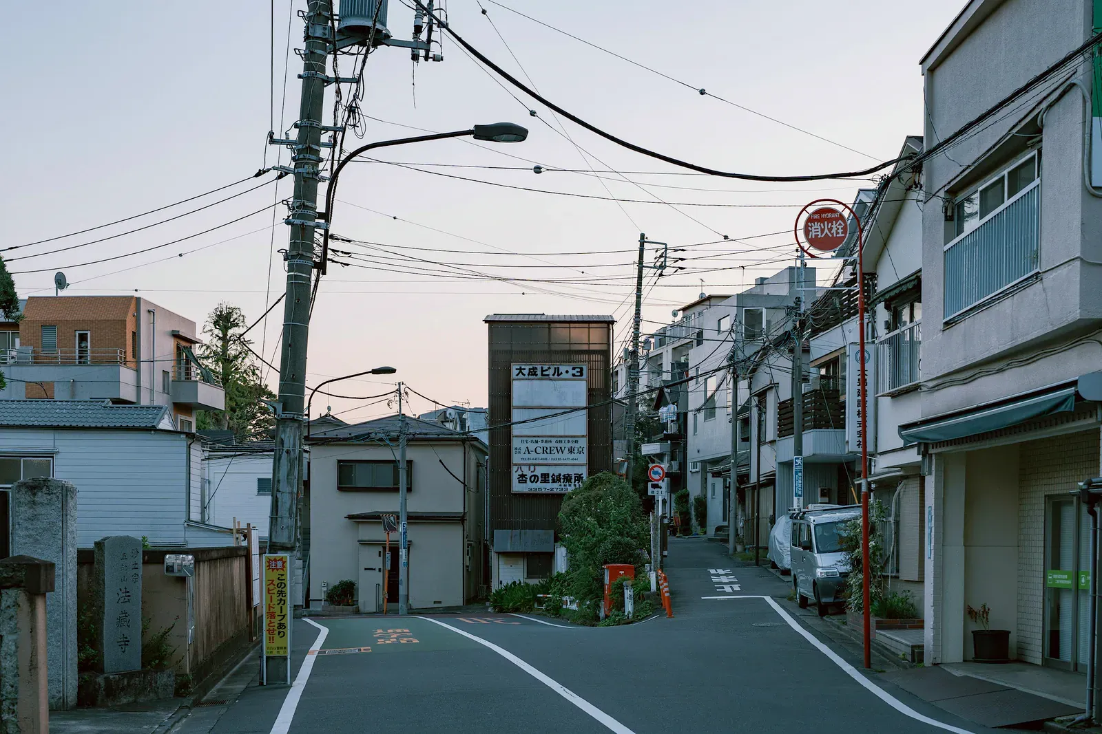 Quiet Tokyo side street with power lines and low houses at dusk