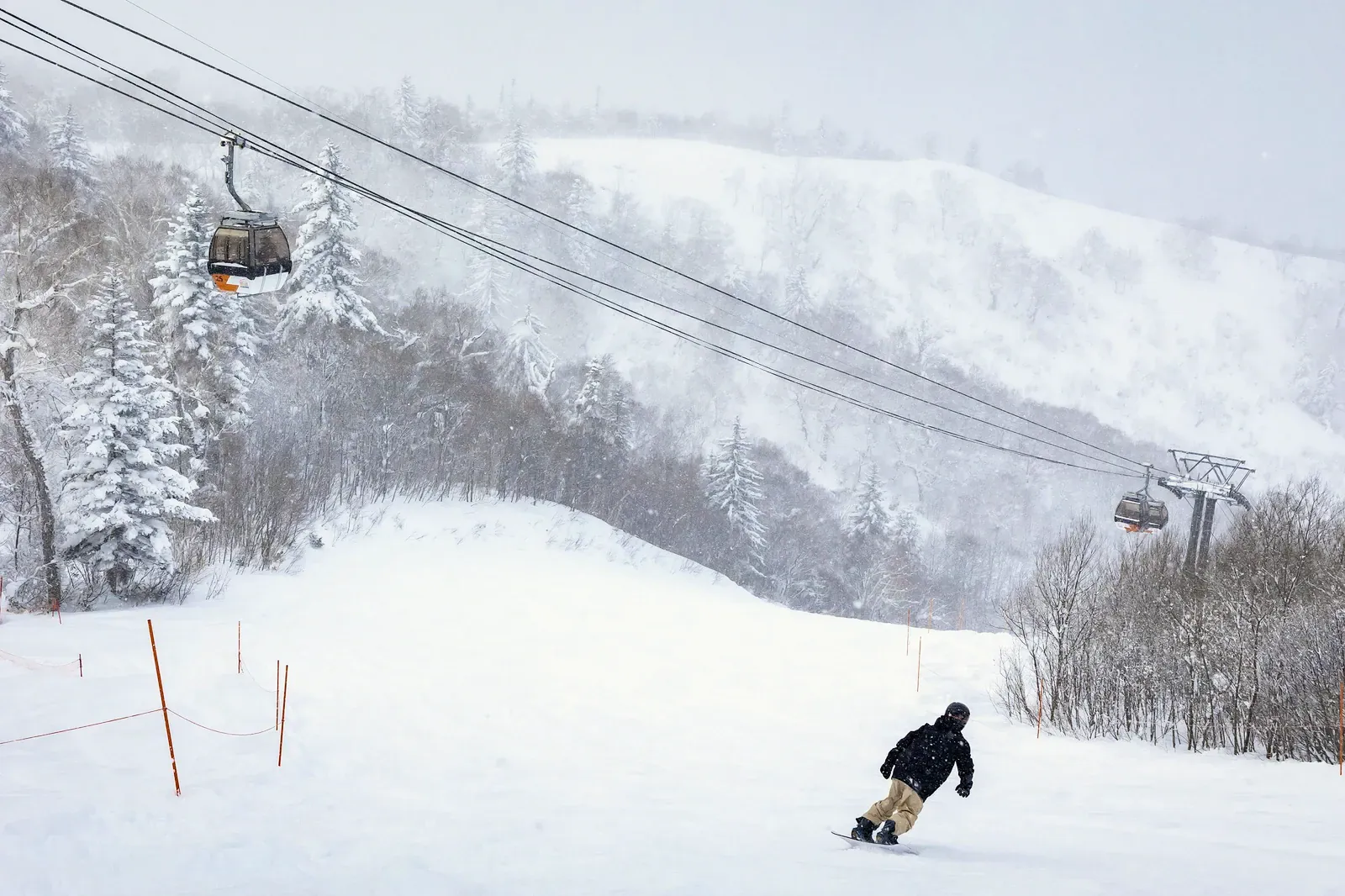 Gondola line above a snowy ski slope in Hokkaido