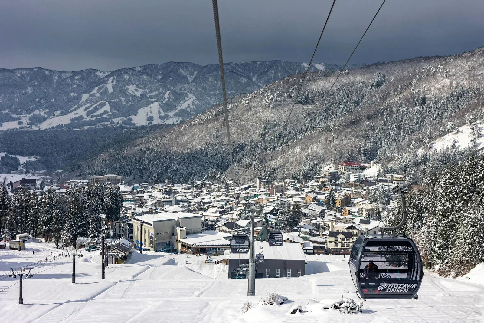 Nozawa Onsen gondola cabin above the snowy village rooftops