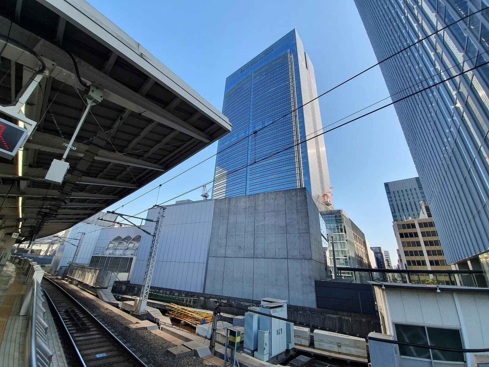 Station platform roofs and glass towers seen from track level